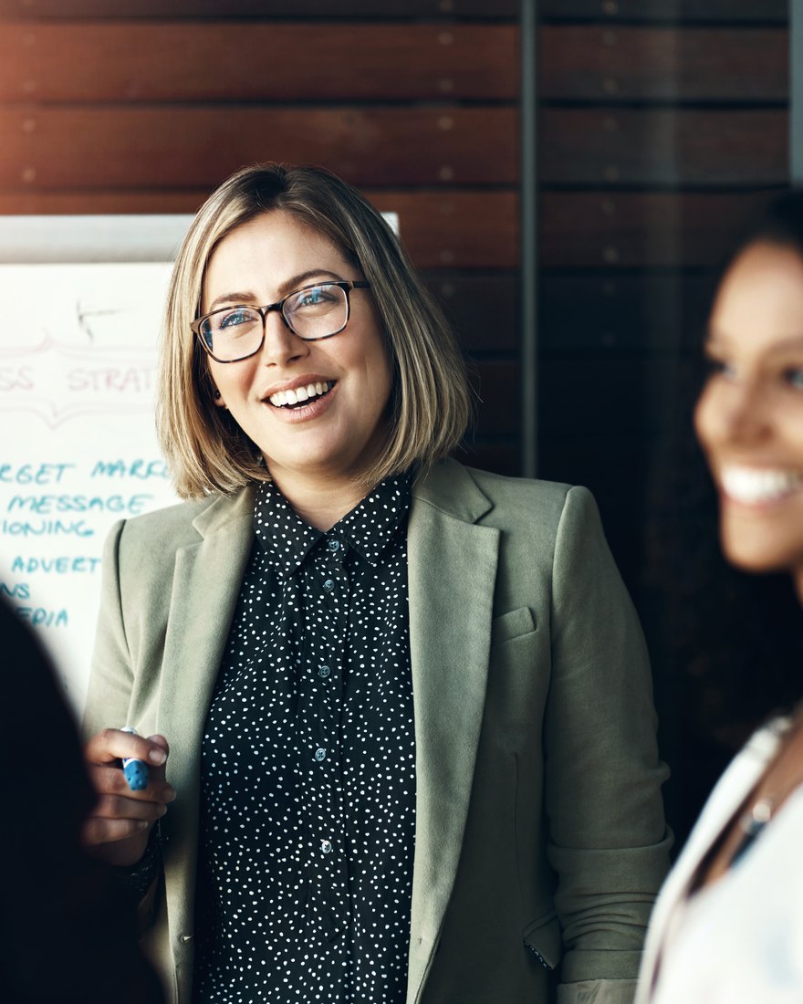 Agency strategist leading a client session in front of a business strategy board