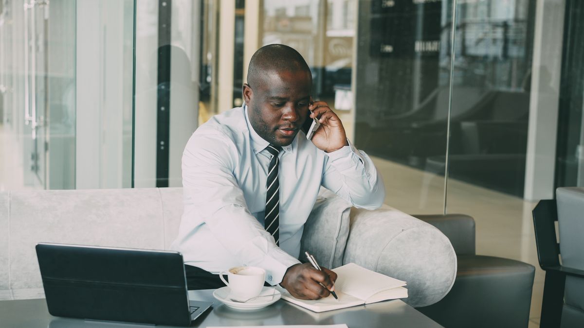 Sales rep following up on a lead by phone while taking notes
